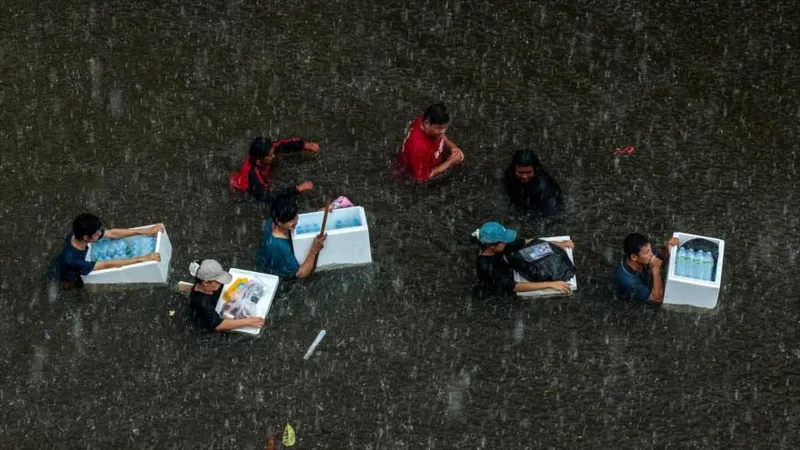 Residentes de Bangkok sortean aguas hasta la cintura por inundaciones
